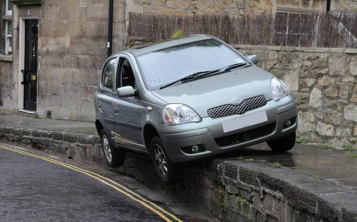 Toyota hangs off curb above double yellow lines