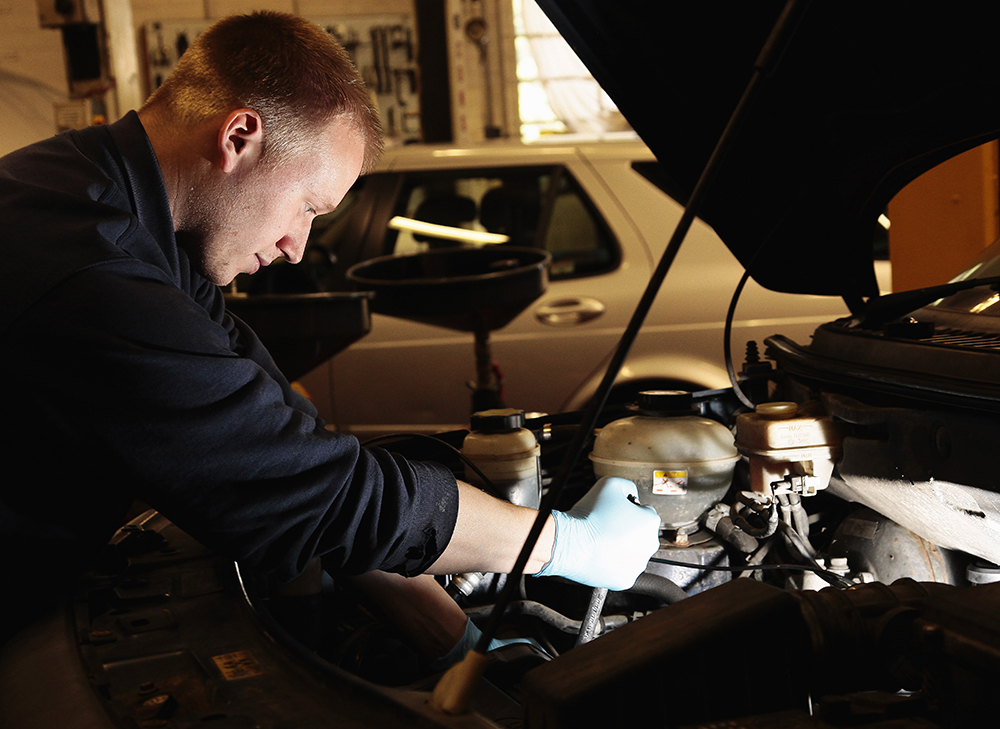 Repair mechanic working on car in garage