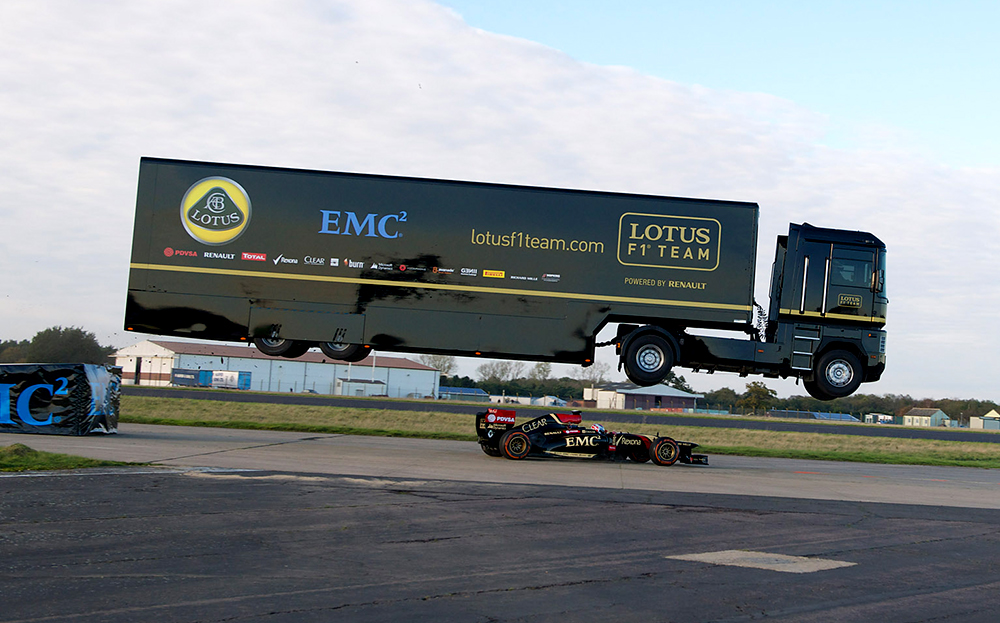 Lotus F1 Team jumps transporter truck over Formula One car