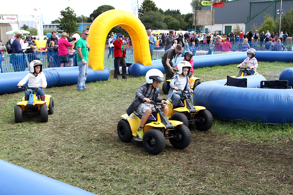 Children ride quad bikes at the Go Compare driving experience area, CarFest South 2015