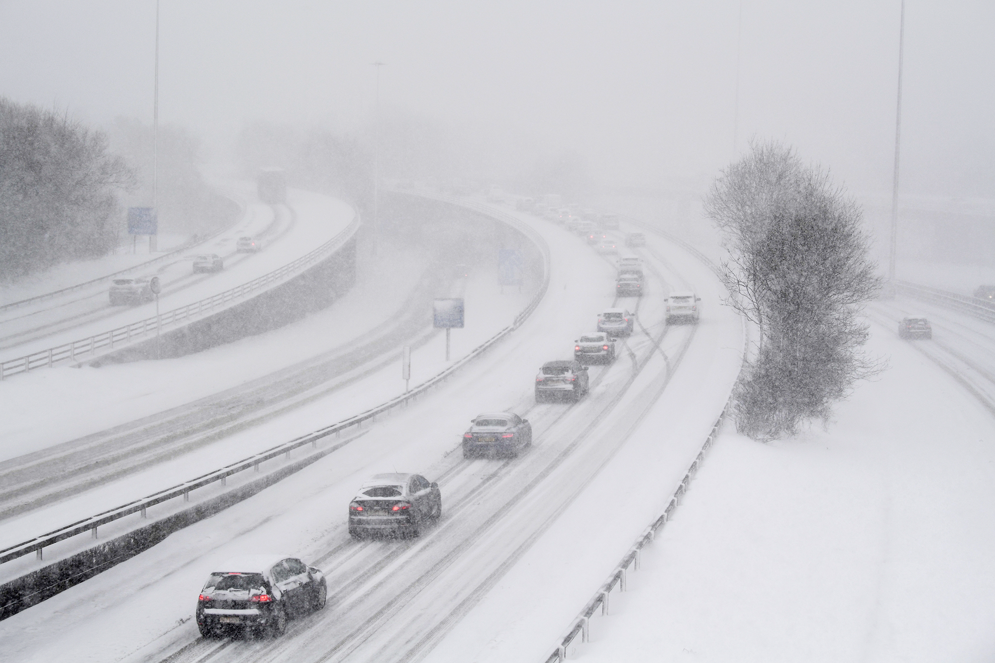 GLASGOW, UNITED KINGDOM - FEBRUARY 28: Vehicles drive through snow on the M8 in Glasgow on February 28, in Glasgow, Scotland. Freezing weather conditions dubbed the 'Beast from the East' bring snow and sub-zero temperatures to the UK. Amber warnings are in place in northern England, the East Midlands, London, the east and south-east of England. Scotland's weather warning has been upgraded to red, which means risk to life, widespread damage, travel and power disruption are likely. (Photo by Jeff J Mitchell/Getty Images)