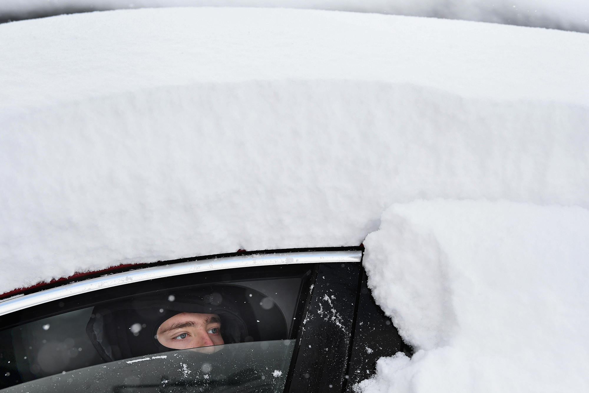 ALEXANDRIA, UNITED KINGDOM - MARCH 01: A boy looks out from snow covered car on March 1, 2018 in Alexandria, Scotland. People have been warned to not to make unnecessary journeys as the Met office issues a red weather be aware warning for parts of Wales and South West England following the one currently in place in Scotland. (Photo by Jeff J Mitchell/Getty Images)