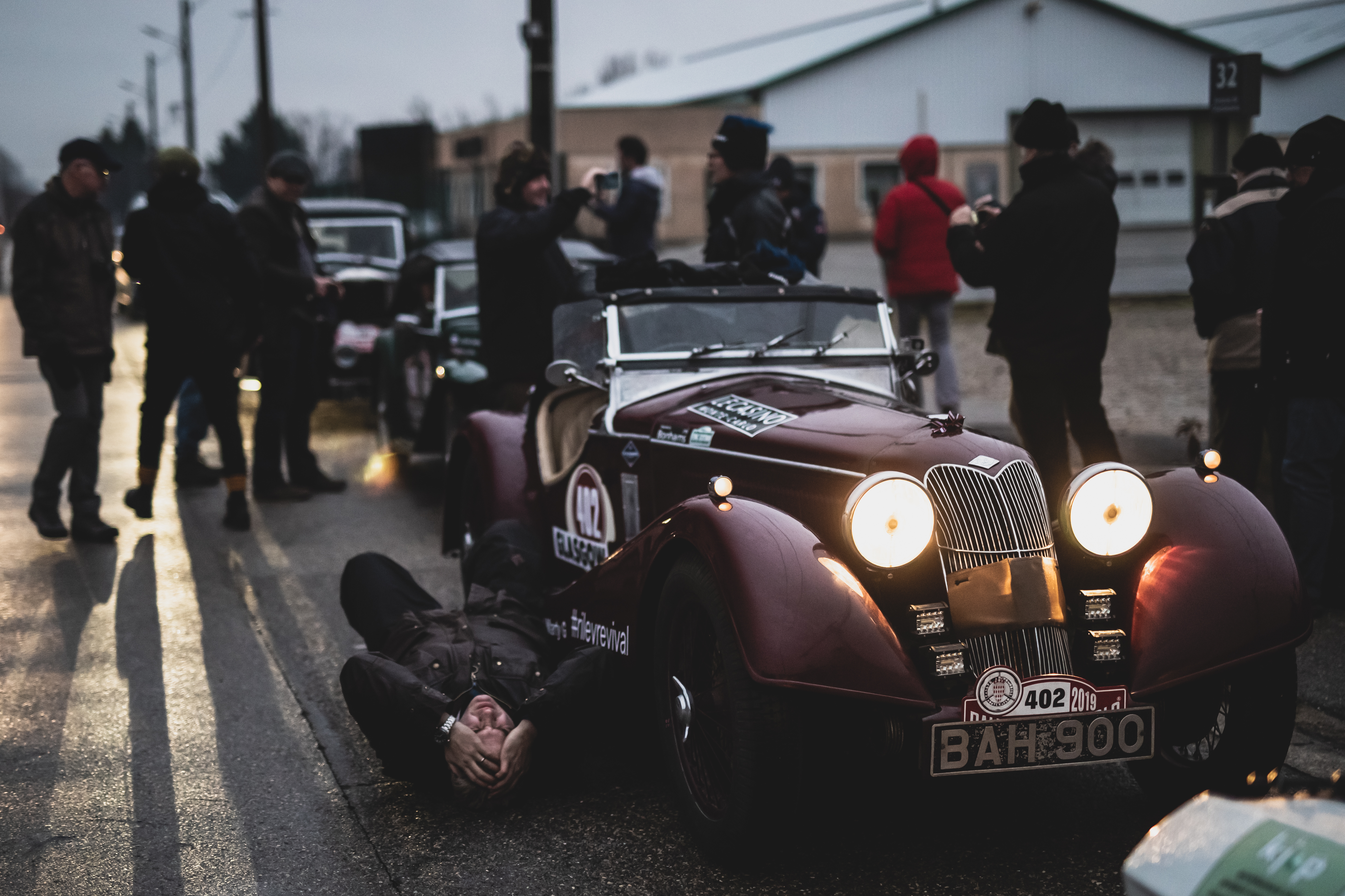 John Lomas lies next to his Riley on the Rallye Monte Carlo Classique 2019