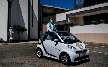 In Portugal, Father Nuno Westood toured the suburb of Oeiras, Lisbon, in convertible Smart car. (Photo by PATRICIA DE MELO MOREIRA/AFP via Getty Images)