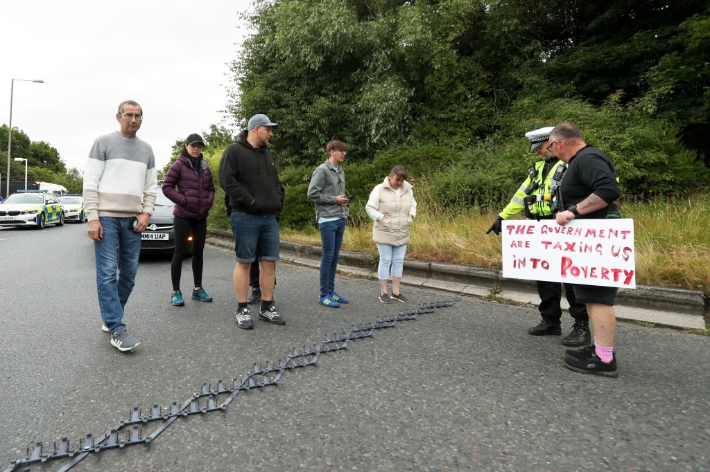 Protesters talk to the police as they block off the exit of Ferrybridge service station with a stinger in Leeds. (Photo by Cameron Smith/Getty Images)