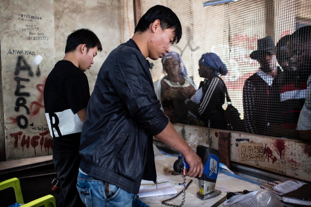 KOLWEZI, DRC: Xu Bin Liu (30) from Hebei in China tests the purity of cobalt he's buying at the Musompo market on the outskirts of Kolwezi. "n"n"nCobalt is a vital mineral needed for the production of rechargeable batteries. Two thirds of the world supply is located in southern Congo where men, women and children all work. Efforts are being made to stop child labor in the cobalt mines, but they have not been successful."n"nBatteries needed for phones, computers and electric cars have pushed the global demand for Cobalt through the roof. Chinese companies and middlemen have the strongest hold on the market. Tech companies like Apple, Microsoft and Tesla are trying to find a way to access Congolese cobalt in a more humane way with proper accountability.