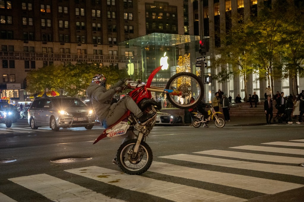 A person rides a dirt bike down Fifth Avenue, New York.