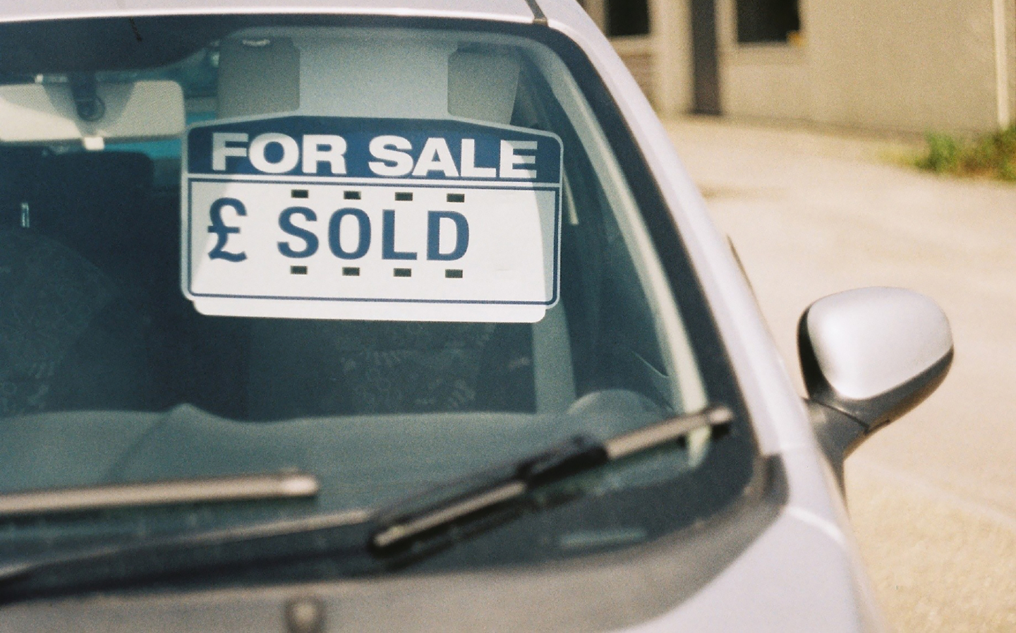 A car with a sold sign at a car dealer