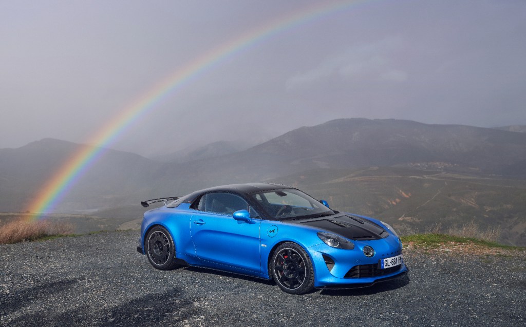 Alpine A110 R on the road, front three-quarters, static against foggy landscape with rainbow in background