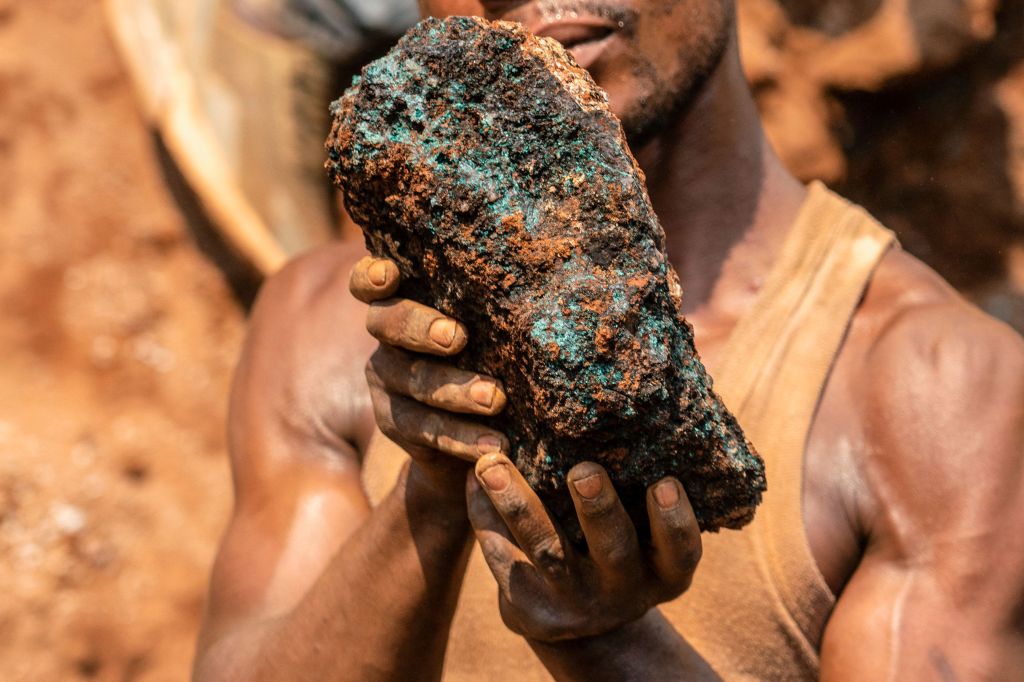 Dela wa Monga, an artisanal miner, holds a cobalt stone at the Shabara artisanal mine near Kolwezi on October 12, 2022. - Some 20,000 people work at Shabara, in shifts of 5,000 at a time. Congo produced 72 percent of the worlds cobalt last year, according to Darton Commodities. And demand for the metal is exploding due to its use in the rechargeable batteries that power mobile phones and electric cars. But the countrys poorly regulated artisanal mines, which produce a small but not-negligeable percentage of its total output, have tarnished the image of Congolese cobalt. (Photo by Junior KANNAH / AFP) (Photo by JUNIOR KANNAH/AFP via Getty Images)