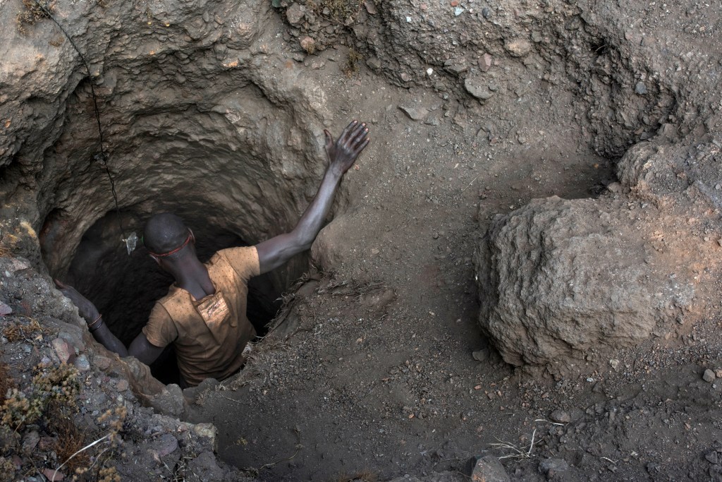 KAWAMA, DEMOCRATIC REPUBLIC OF CONGO - JUNE 8 A creuseur, or digger, descends into a copper and cobalt mine in Kawama, Democratic Republic of Congo on June 8, 2016. Cobalt is used in the batteries for electric cars and mobile phones. Working conditions are dangerous, often with no safety equipment or structural support for the tunnels. The diggers say they are paid on average US$2-3/day. (Michael Robinson Chavez/The Washington Post via Getty Images)