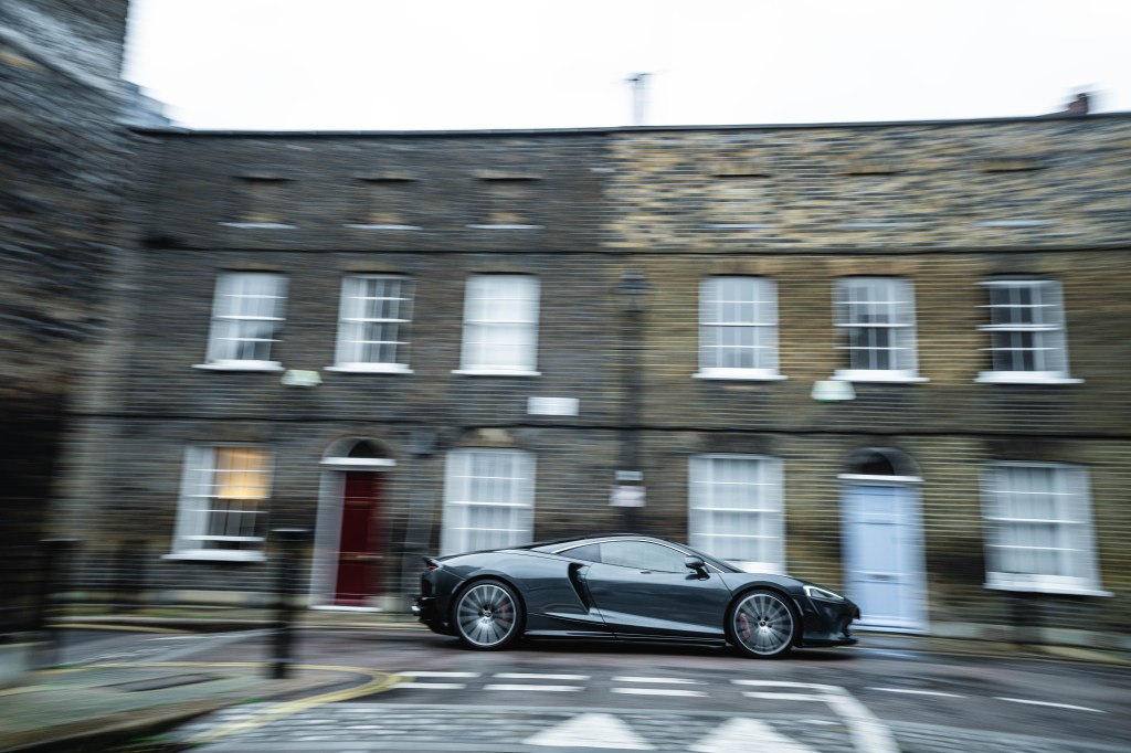 McLaren GT driving past on residential street