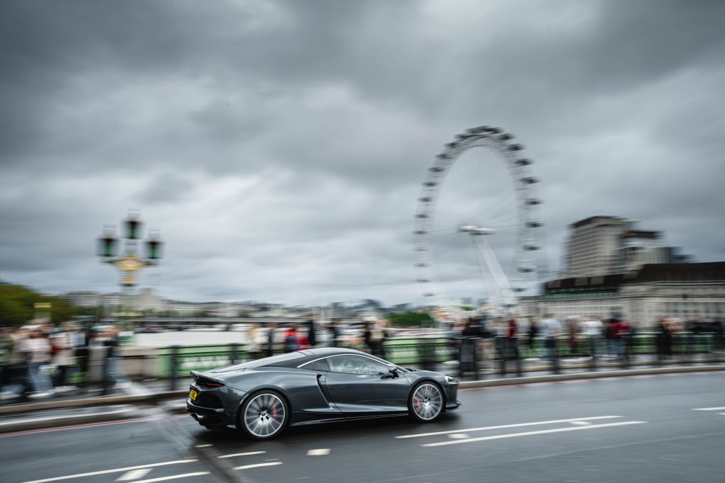 McLaren GT drives over Westminster Bridge with London Eye in background