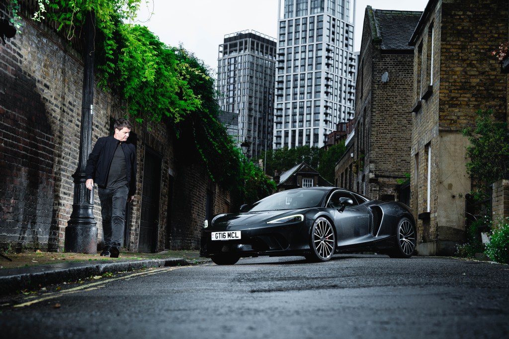 David Green looks at the McLaren GT as he walks past on a quiet residential street in central London.