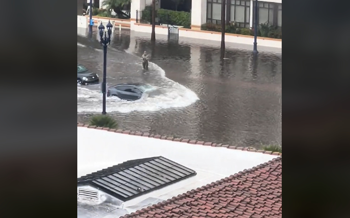 A Tesla drives through flood water in San Diego