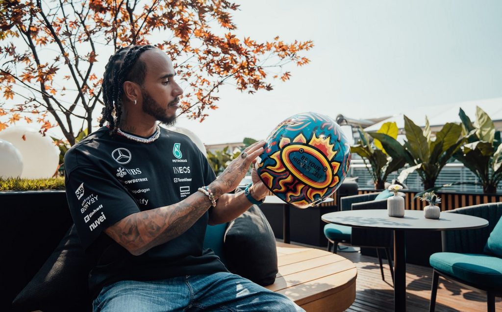 Lewis Hamilton with helmets designed by Ineos competition winners